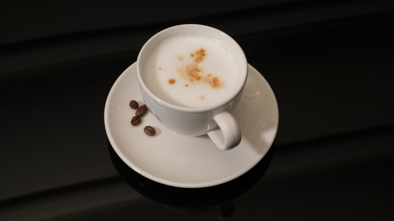 Elegant coffee cup with creamy foam and beans, perfect for coffee enthusiasts.